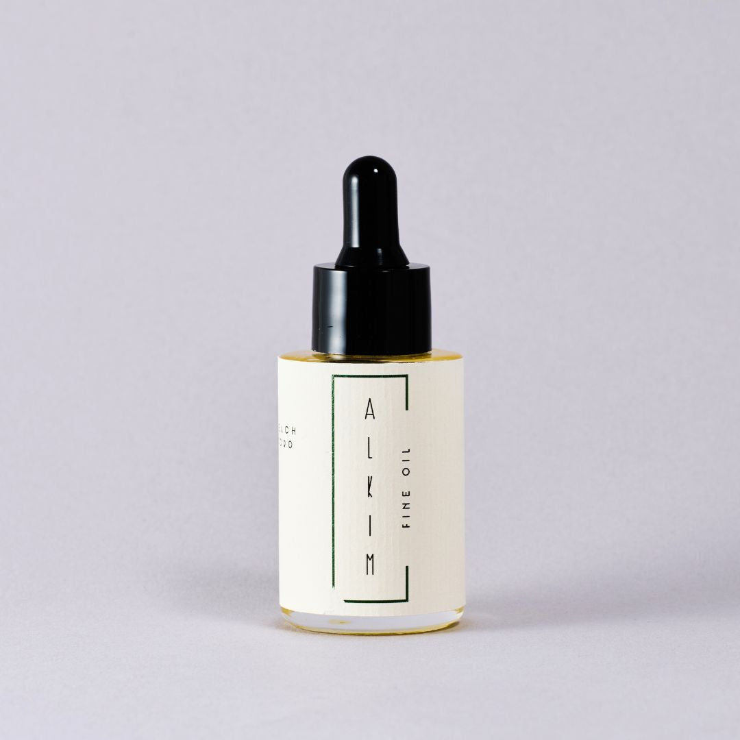 Skincare dropper bottle with 'ALKIM' branding on a light gray background