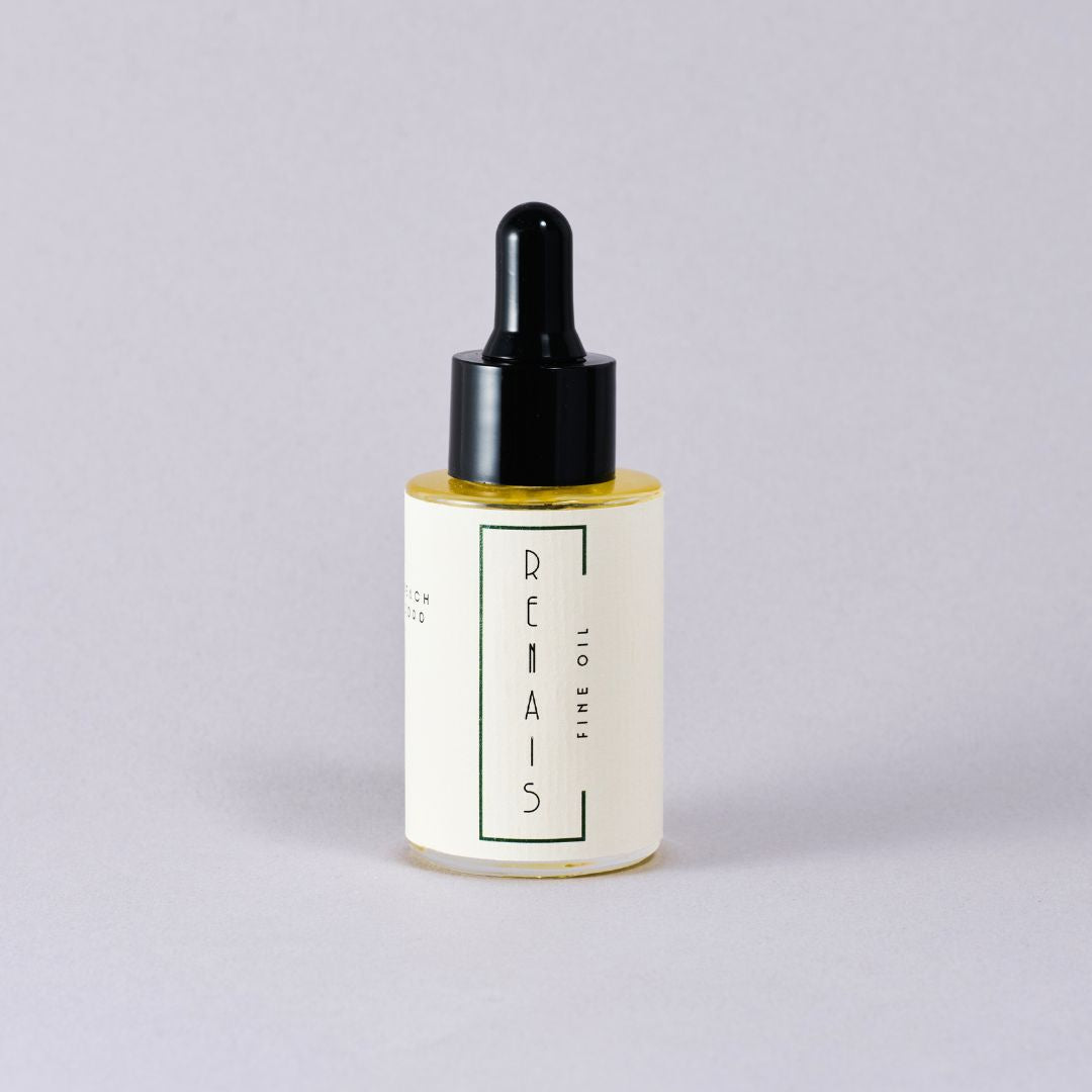 Bottle of RENAIS fine oil with a black dropper on a light gray background