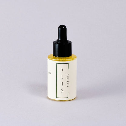 Bottle of skincare oil with dropper on a light gray background