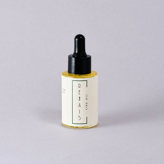 Bottle of RENAIS skincare oil with dropper on a light gray background