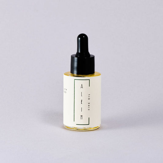 Skincare dropper bottle 'ALKIM' with a white label on a light gray background