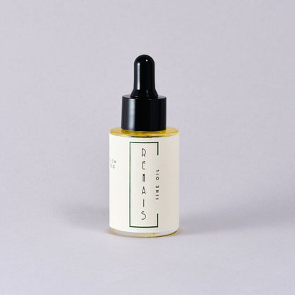Bottle of RENAIS fine oil with a black dropper on a light gray background